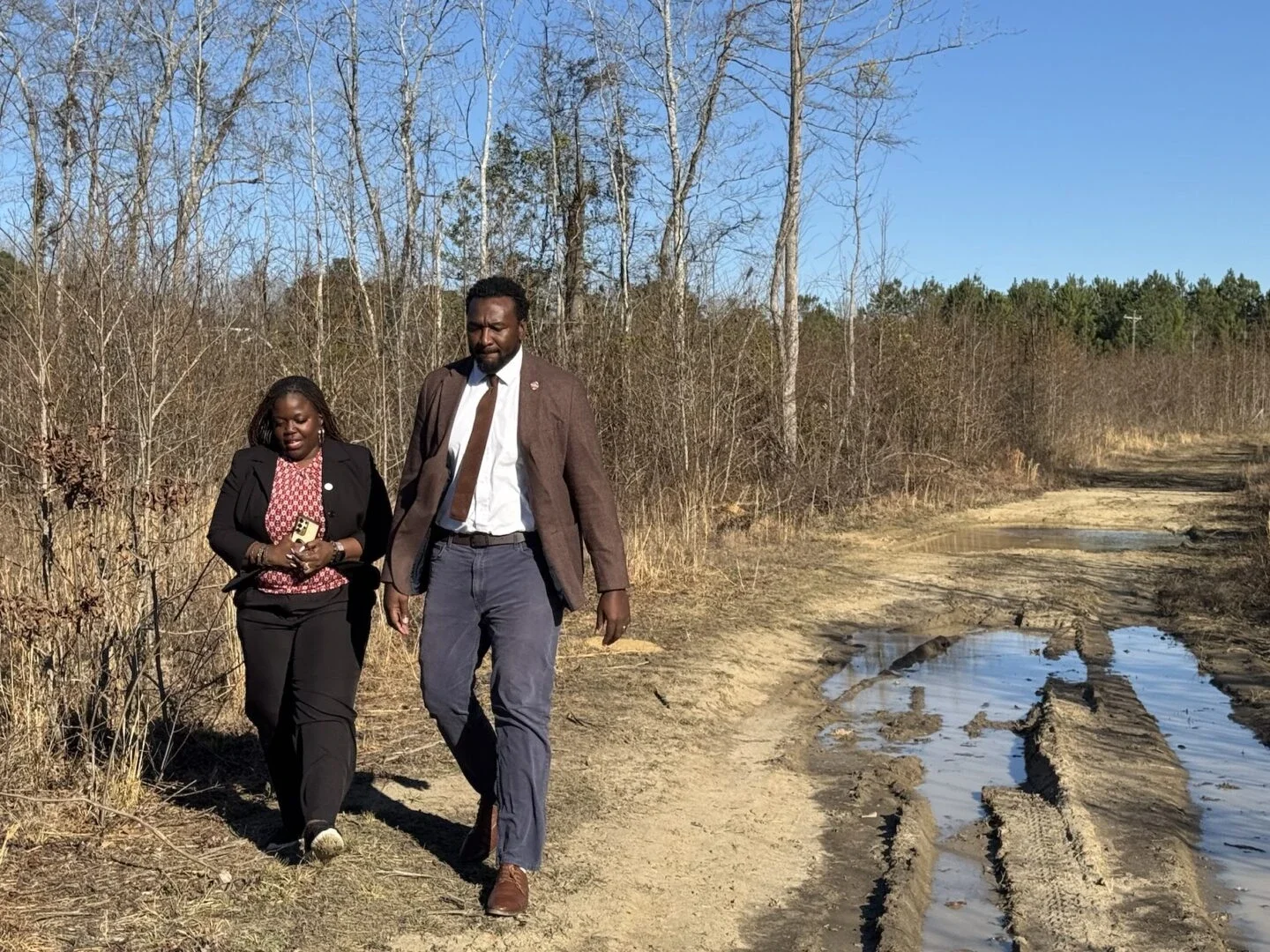 Optus's Tereacy Pearson and Rep. Dr. Jermaine Johnson walking the solar farm land in Hopkins, South Carolina (Photo Credit Masha Hamilton)